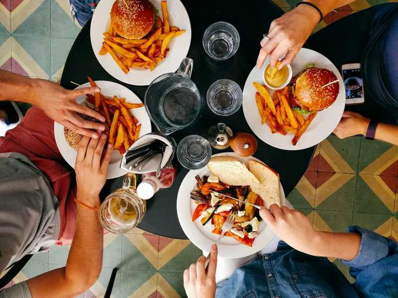 Friends sharing burgers and fries, seen from above